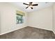 Neutral bedroom featuring carpet, a ceiling fan, and a window with blinds for natural light at 15366 Sandfield Loop, Winter Garden, FL 34787
