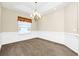 Bright dining room with wainscoting, a chandelier, and a large window, perfect for entertaining at 15366 Sandfield Loop, Winter Garden, FL 34787