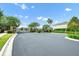 Gated community entrance with a paved road, manicured landscaping, and brick pillars at 15366 Sandfield Loop, Winter Garden, FL 34787