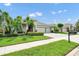 Charming single-story home with a three-car garage, manicured lawn, and lush tropical landscaping at 15366 Sandfield Loop, Winter Garden, FL 34787