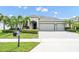 Inviting exterior with well-manicured lawn, lush landscaping, and a three car garage at 15366 Sandfield Loop, Winter Garden, FL 34787