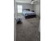 The carpeted bedroom has a ceiling fan, window, and is decorated with a bed and a side table at 1540 Fleur Dr, Davenport, FL 33837