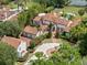 Stunning aerial view of a custom estate with a terracotta tile roof, lush landscaping, circular driveway, and resort-style pool at 1640 E Adams Dr, Maitland, FL 32751