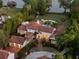 Stunning aerial view of a luxury home with a terracotta roof, manicured landscaping, and a pool overlooking the waterfront at 1640 E Adams Dr, Maitland, FL 32751