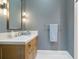 Bright bathroom with a wood vanity, a stone countertop, and sleek chrome fixtures at 1640 E Adams Dr, Maitland, FL 32751