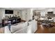 Open-concept living room flowing into a modern kitchen, featuring hardwood floors and contemporary furnishings at 1640 E Adams Dr, Maitland, FL 32751