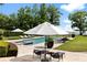 Sparkling swimming pool surrounded by patio, lounge chairs, umbrellas, and lush greenery offering a luxurious outdoor experience at 1640 E Adams Dr, Maitland, FL 32751