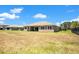 Expansive backyard view of the home, showing a spacious lawn and exterior features at 18108 Bellezza Dr, Orlando, FL 32820
