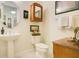 Bathroom view with white pedestal sink, toilet, and wood cabinet at 18108 Bellezza Dr, Orlando, FL 32820