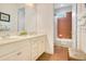 Bright bathroom featuring double sink vanity, tiled floor, and shower with a partial glass enclosure at 18108 Bellezza Dr, Orlando, FL 32820