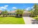 Charming single-story home with a well-manicured lawn, lovely landscaping, and a brick-paved driveway at 18108 Bellezza Dr, Orlando, FL 32820