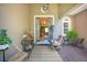 Inviting front porch with decor, seating, and a charming open door to welcome you home at 18108 Bellezza Dr, Orlando, FL 32820