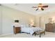 A view of the main bedroom with a ceiling fan, tray ceiling, and carpeted floor at 18108 Bellezza Dr, Orlando, FL 32820