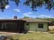 Image displays the rear exterior, including a screened-in patio, roof, and a glimpse of the green lawn at 1872 N Akron Dr, Deltona, FL 32738