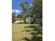 View of a charming backyard shed with double doors, surrounded by a lush green lawn and mature trees at 1872 N Akron Dr, Deltona, FL 32738