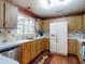 Kitchen with wood-look cabinets, stainless dishwasher, and full-size white refrigerator at 1872 N Akron Dr, Deltona, FL 32738