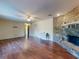 Spacious living room featuring wood floors, a brick fireplace, and a ceiling fan at 1872 N Akron Dr, Deltona, FL 32738