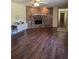 View of the living room featuring hardwood floors, a brick fireplace, and a glimpse into adjacent hallways at 1872 N Akron Dr, Deltona, FL 32738