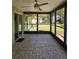 The screened-in patio features tiled flooring, fan, providing a cozy outdoor living space with backyard views at 1872 N Akron Dr, Deltona, FL 32738