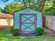 A light blue shed with brown trim sits on a manicured lawn at 1872 N Akron Dr, Deltona, FL 32738