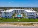 Aerial view of white condo features sparkling pool, pristine landscaping, and ample parking at 1926 Ocean Shore Blvd # 3120, Ormond Beach, FL 32176