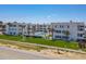 Exterior view of the building, pool and green space with palm trees at 1926 Ocean Shore Blvd # 3120, Ormond Beach, FL 32176