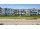 Exterior shot of a beachfront condo with a manicured lawn, palm trees, and a communal pool at 1926 Ocean Shore Blvd # 3120, Ormond Beach, FL 32176