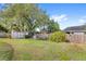 Spacious backyard featuring a storage shed, mature trees, and a wood fence at 1994 Excalibur Dr, Orlando, FL 32822
