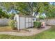 Backyard shed offering extra storage and a neat, tidy space, complemented by landscaping and a paved area at 1994 Excalibur Dr, Orlando, FL 32822