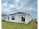 A newly constructed white home features a covered patio and a well maintained lawn at 2013 Stone Wall Ct, Lake Hamilton, FL 33851