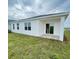Newly constructed white home with a covered patio area and freshly installed green grass at 2013 Stone Wall Ct, Lake Hamilton, FL 33851