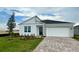 Charming single-story home with a two-car garage, brick driveway, and fresh landscaping at 2013 Stone Wall Ct, Lake Hamilton, FL 33851