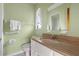 Green bathroom featuring white fixtures, a wooden-style countertop, and a mirror at 2138 Whitehall Dr, Winter Park, FL 32792