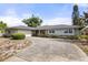 Charming single-story home featuring a curved driveway, attached garage and neatly landscaped front yard at 2138 Whitehall Dr, Winter Park, FL 32792