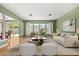 Bright living room featuring a white sofa, plush seating, and a large window with outdoor views at 2138 Whitehall Dr, Winter Park, FL 32792
