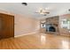 Spacious living room featuring a brick fireplace, hardwood floors, and natural light from two windows at 2138 Whitehall Dr, Winter Park, FL 32792