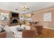 Bright living room featuring a brick fireplace, a ceiling fan and an open view to the kitchen bar at 2138 Whitehall Dr, Winter Park, FL 32792