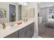 Bathroom with double sink vanity and light countertops, with bedroom visible in the background at 2332 Salty Winds Way, Kissimmee, FL 34747