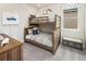 Cozy bedroom with a bunk bed, coastal-themed artwork, and window at 2332 Salty Winds Way, Kissimmee, FL 34747