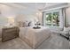 Comfortable bedroom featuring a decorative tray ceiling, and a large window to the landscaped yard at 2332 Salty Winds Way, Kissimmee, FL 34747