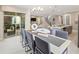 Dining area with modern decor featuring a chandelier, staircase and access to the lanai at 2332 Salty Winds Way, Kissimmee, FL 34747
