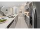 Modern kitchen featuring an island with seating, stainless appliances and grey cabinetry at 2332 Salty Winds Way, Kissimmee, FL 34747