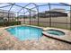 Sparkling in-ground pool and spa surrounded by brick pavers and a black screen enclosure at 2332 Salty Winds Way, Kissimmee, FL 34747