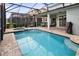Sparkling in-ground pool and spa surrounded by brick pavers and a black screen enclosure at 2332 Salty Winds Way, Kissimmee, FL 34747