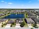Aerial view of a home in a lakefront community featuring solar panels and a three-car garage at 2614 Mead Ave, St Cloud, FL 34771