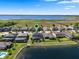 Aerial view of houses along a lake, featuring a home with solar panels and an outdoor area by the water at 2614 Mead Ave, St Cloud, FL 34771