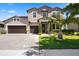 Charming two-story home featuring a three-car garage, landscaped yard, and a paver driveway under a sunny sky at 2614 Mead Ave, St Cloud, FL 34771