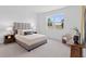Bright bedroom featuring neutral decor, a large window, and a comfortable upholstered bed at 2770 Sweet Acacia Dr, Clermont, FL 34711