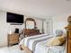 A bright bedroom featuring wood furnishings, wall-mounted TV, and tile flooring at 2803 Charing Cross Way, Orlando, FL 32837