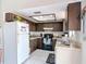 The kitchen includes dark wood cabinets, white appliances, and tile floors at 2803 Charing Cross Way, Orlando, FL 32837